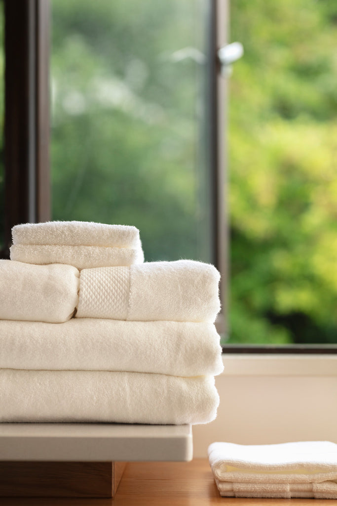 Inish Living luxury towels in a bundle together with a window in the background