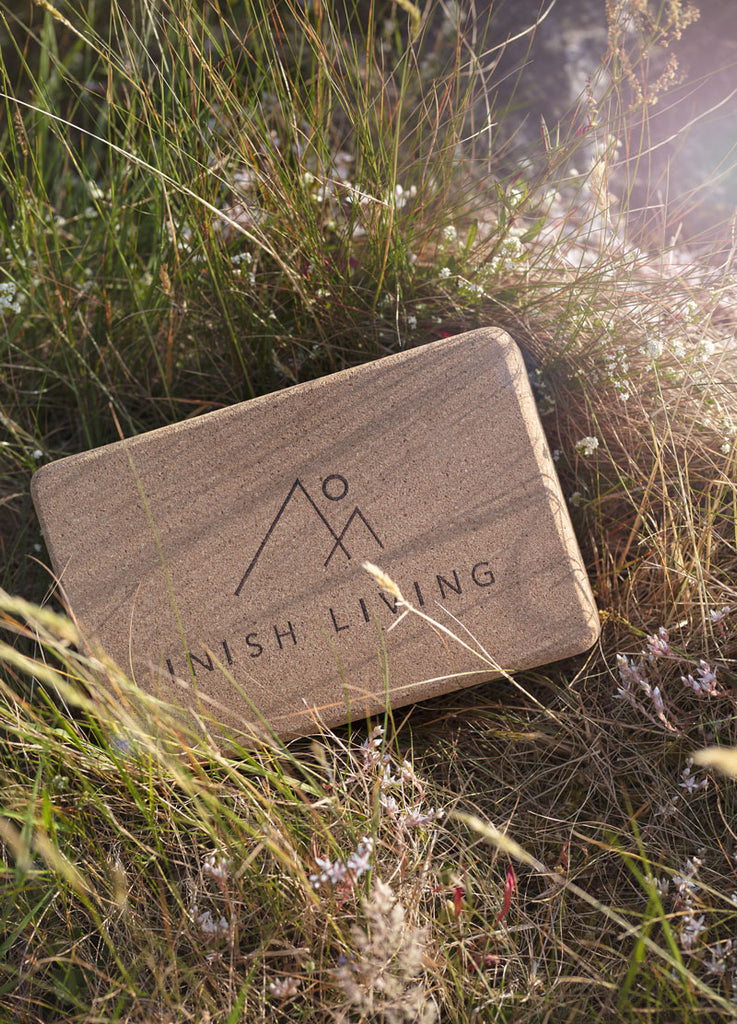 Cork yoga block in the reeds with Inish Living written on it