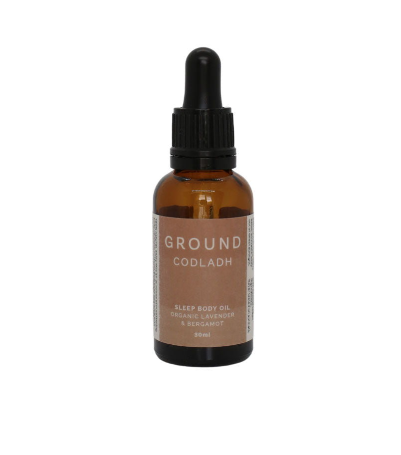 Bottle of oil called Ground Codladh Sleep body oil on a white background