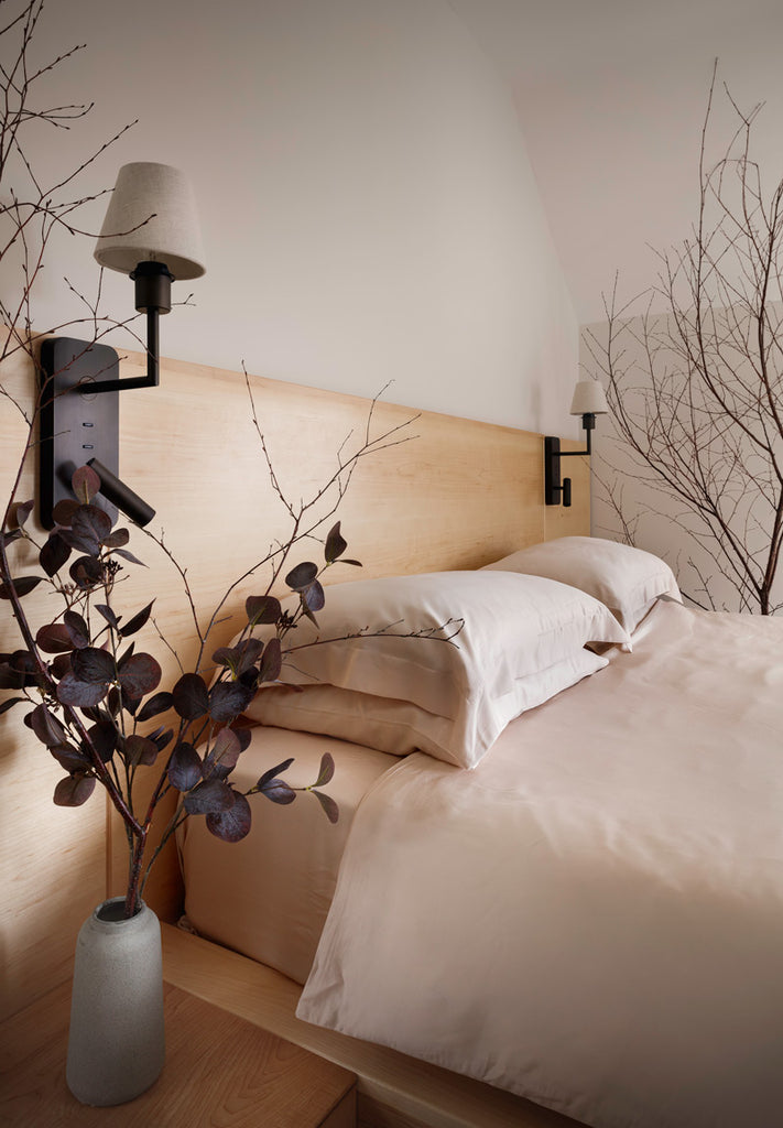 Bed fully made with Inish Living 100% TENCEL Lyocell bed linen. Flowers on either side of the double bed